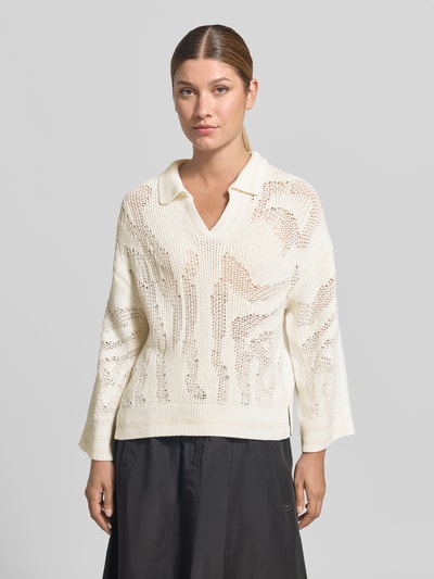 Frauenmodel trägt Strickpullover mit Stehkragen und V-Ausschnitt von Marc Cain in Weiß, Baumwoll-Mix mit Viskose, lockere Struktur, Ganzkörperansicht von vorne.