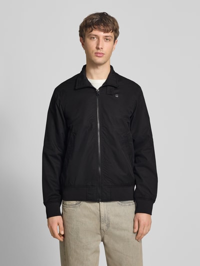 Männermodel trägt schwarze Jacke mit Stehkragen und Reißverschluss von G-Star Raw, Baumwoll-Mix, Regular Fit, Ganzkörperansicht von vorne.