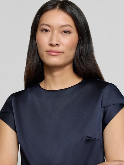 Frauenmodel trägt Bluse aus Satin von Rinascimento in Dunkelblau mit Rundhalsausschnitt und kurzem Arm, Nahaufnahme Oberkörper.