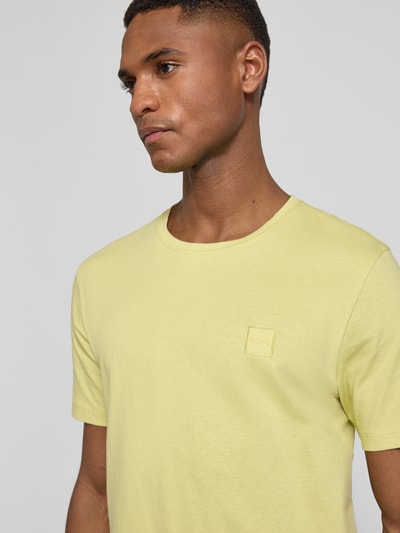 Männermodel trägt Regular Fit T-Shirt aus reiner Baumwolle Modell 'TALES' von BOSS Orange, unifarben, Nahaufnahme Oberkörper.