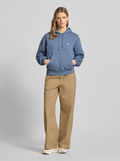 Kobiece modelka nosi Oversized Hoodie aus Baumwoll-Mix Modell 'CASEY' od Carhartt Work In Progress, niebieski, wyhaftowane logo, prążkowane zakończenia, kieszeń kangurka, widok całej sylwetki z przodu.