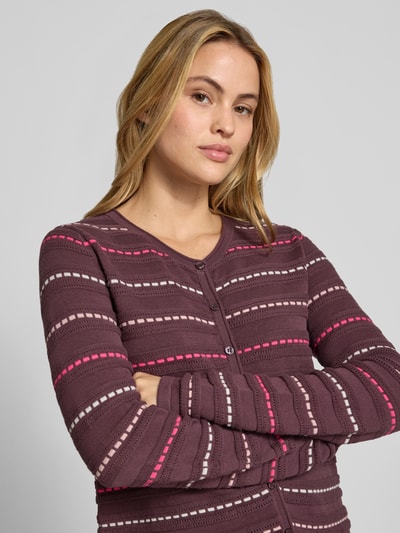 Frauenmodel trägt Cardigan aus reiner Baumwolle von Christian Berg Woman, violett mit pink-rosa Streifen, eng anliegend, Nahaufnahme Oberkörper.