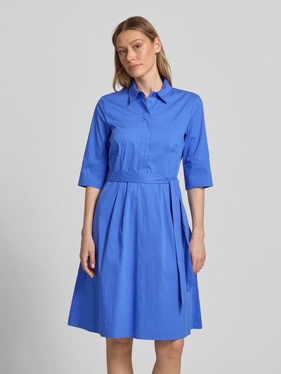 Modelka kobieca nosi niebieską sukienkę 'Knielanges Hemdblusenkleid mit Bindegürtel' od Christian Berg Woman Selection z bawełnianego miksu ze stretchu, fason A-linia, kryta listwa guzikowa, pasek, długość do kolan, długość tyłu w rozmiarze 36: 99 cm, szerokość w rozmiarze 36: 48 cm, długość rękawa w rozmiarze 36: 37 cm, widok całej sylwetki z przodu