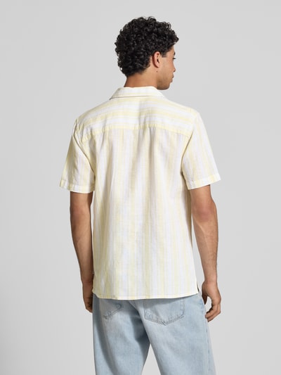 Männermodel trägt Regular Fit Leinenhemd aus Baumwoll-Leinen-Mix Modell 'CAIDEN' von Only & Sons mit gelb-weißem Allover-Streifenmuster, Kurzarm, Rückenpasse, Resortkragen, Ganzkörperansicht Rückansicht.
