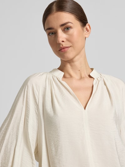 Frauenmodel trägt Bluse aus Viskose-Mix mit Serafino-Ausschnitt von Christian Berg Woman, lockere Passform, Nahaufnahme Oberkörper.