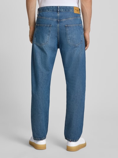 Männermodel trägt Loose Fit Jeans aus reiner Baumwolle Modell 'RUNNE' von Marc O'Polo DENIM in Mittelblau, Ganzkörperansicht Rückansicht.
