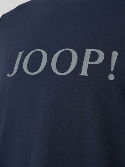 Männermodel trägt Longsleeve mit Logo und Rundhalsausschnitt von JOOP! Collection, dunkelblauer Baumwoll-Elasthan-Mix, Relaxed-Fit, Nahaufnahme Oberkörper