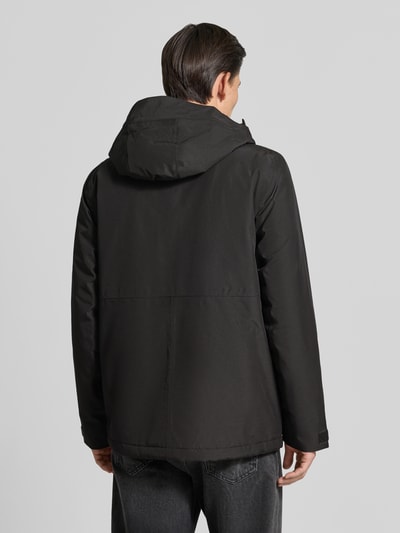 Männermodel trägt Regular Fit Jacke mit Kapuze Modell 'Adam' von Didriksons in Schwarz, glatte Struktur, Ganzkörperansicht Rückansicht. Rückenlänge bei Größe M: 79 cm, Schulterbreite: 46 cm, Brustweite: 58 cm, Ärmellänge: 73 cm.