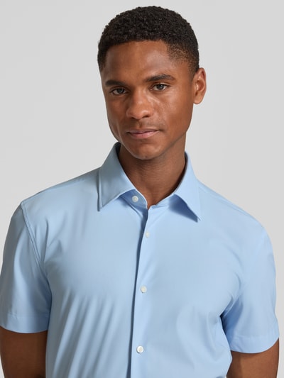 Männermodel trägt Slim Fit Businesshemd mit kurzem Arm Modell 'P-HANK-K-SH-262' von BOSS in Hellblau, feuchtigkeitsregulierend, Kentkragen, Nahaufnahme Oberkörper.