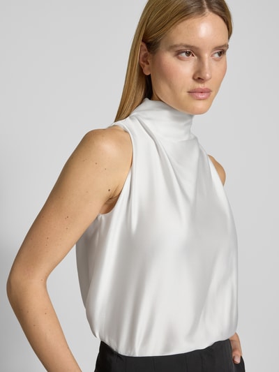 Frauenmodel trägt Blusentop aus Satin mit Raffungen von SWING in Weiß, Stehkragen, Regular-Fit, Rückenlänge 61 cm, Nahaufnahme Oberkörper.