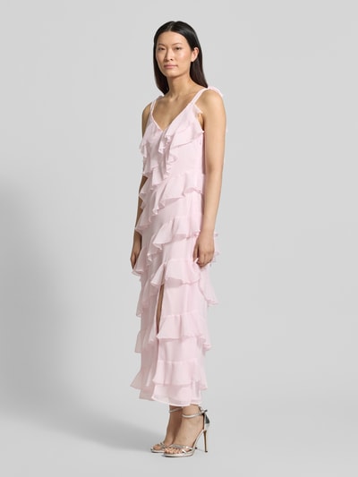 Frauenmodel trägt Damen Midikleid mit Volants Modell 'LUNA' von Vila in zartem Rosa, A-Linie, Träger mit Schnürung, Ganzkörperansicht von vorne. Rückenlänge 115 cm, Brustweite 43 cm bei Größe 36, luftige Textur.