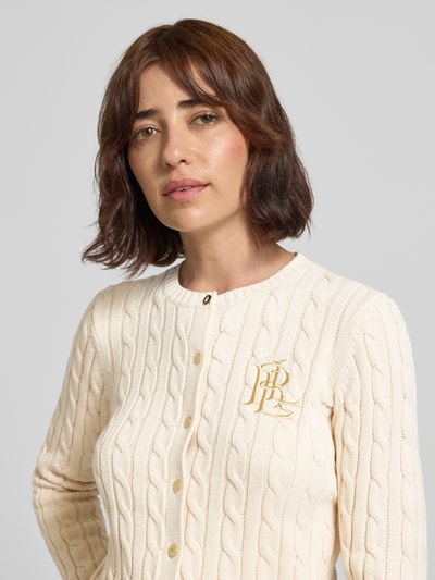 Frauenmodel trägt cremefarbene Regular Fit Strickjacke aus reiner Baumwolle Modell 'RALHAN' von Lauren Ralph Lauren, Nahaufnahme Oberkörper. Damen Strickjacke.