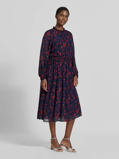 Frauenmodel trägt Midikleid mit Rüschenkragen und Raglanärmeln von Christian Berg Woman Selection, dunkelblau mit rotem Blumenmuster, semitransparente Ärmel, taillierter Schnitt, blickdichtes Unterkleid, Ganzkörperansicht von vorne.