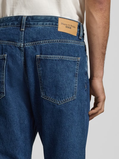 Männermodel trägt Herren Tapered-Fit Jeans aus reiner Baumwolle Modell 'RUNNA' von Marc O'Polo Denim, Denim-Optik, Label-Patch, Kontrastnähte, 5-Pocket-Design, Detailaufnahme Rückansicht.