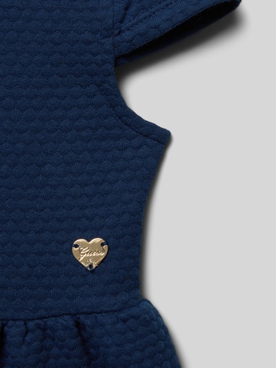 Mädchen trägt Regular Fit Kleid mit Logo-Applikation von Guess, Strukturmuster, elastischer Material-Mix mit Baumwoll-Anteil, Detailaufnahme