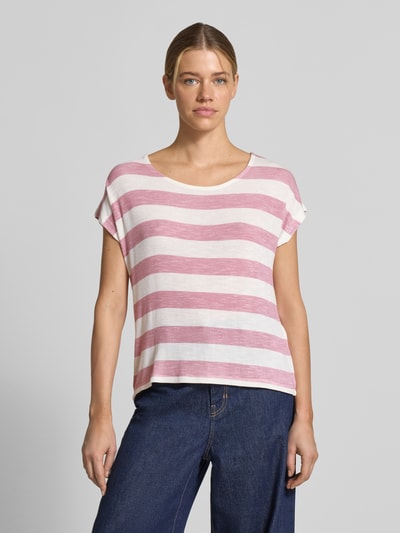 Frauenmodel trägt Boxy Fit T-Shirt aus Viskose-Mix Modell 'WIDE STRIPE' von Vero Moda mit Optik:Allover-Muster, Streifenmuster in Rosa und Weiß, Rundhals, Kurzarm, Rumpfabschluss: Asymmetrisch, Feinstrick. Ganzkörperansicht von vorne.