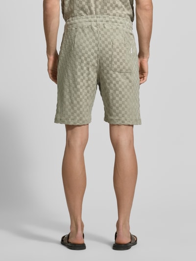 Männermodel trägt Regular Fit Shorts mit Label-Patch von Lindbergh aus Baumwoll-Mix mit Eingrifftaschen und Gesäßtasche, Ganzkörperansicht Rückansicht.