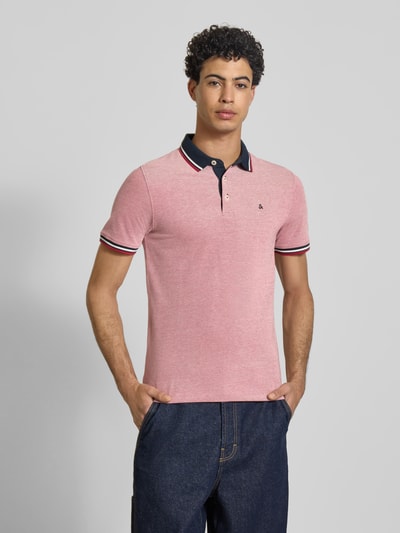 Męski model nosi Koszulkę polo Slim Fit z dodatkiem wiskozy Model 'Paulos' od JACK & JONES, mieszanka bawełny i wiskozy, kołnierzyk polo, krótki rękaw, wyhaftowane logo, długość tyłu w rozmiarze M: 72 cm, widok całej sylwetki z przodu.