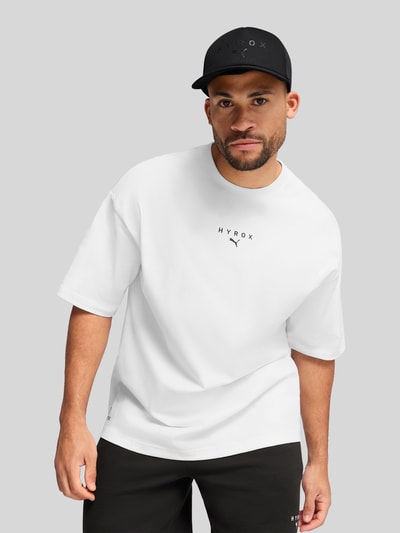 Männermodel trägt Basecap mit Label-Print von PUMA PERFORMANCE aus reiner Baumwolle, verstärkter Schirm, semitransparenter Einsatz, verstellbarer Verschluss, Ganzkörperansicht von vorne.