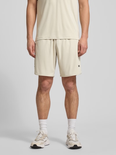 Männermodel trägt Regular Fit Shorts mit Label-Schriftzug Modell 'TOC SPIN 9 INCH' von BOSS Green, Unifarben, Tunnelzugbund, seitliche Eingrifftaschen, Logo-Detail, Ganzkörperansicht von vorne.