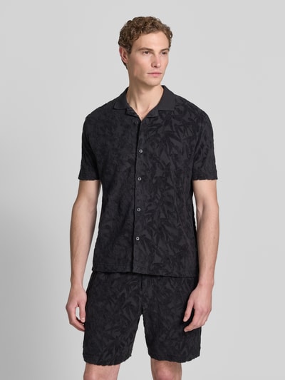 Männermodel trägt Regular Fit Freizeithemd aus reiner Baumwolle von Marc O'Polo, Optik: Unifarben, Passform: Regular-Fit, Hemdkragen: Resort-Kragen, Knopfleiste: durchgehend, Muster: Allover-Muster, Applikation: Label-Patch, Verschluss: einreihige Knopfleiste, Ärmelform: Kurzarm, Materialverarbeitung: Jacquard, Material: reine Baumwolle, dezente Struktur, dunkle Farbtöne, Ganzkörperansicht von vorne.