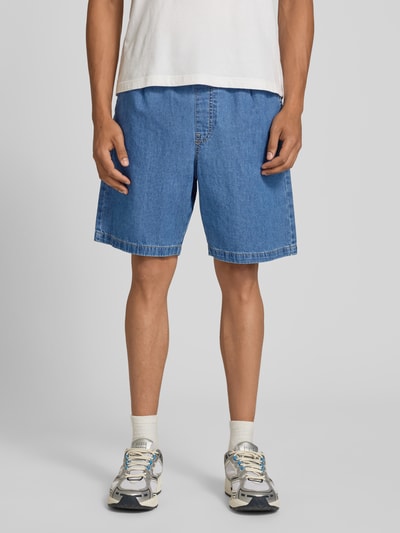 Mężczyznamodel nosi szorty z elastycznym pasem i trokiem model 'TONY' od Jack & Jones z bawełny, krój straight fit, kolor niebieski, długość wewnętrzna nogawki 20 cm, szerokość w rozmiarze M 43 cm, kieszenie z tyłu. Ganzkörperansicht von vorne.