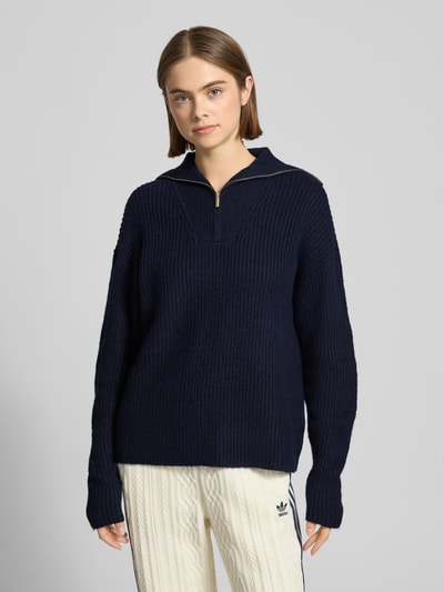 Vrouwenmodel draagt donkerblauwe Strickpullover mit Reißverschluss Modell 'Kylie' van LeGer by Lena Gercke, grof breisel, relaxed fit, mix van materialen met wol, volledige voorkant weergave.