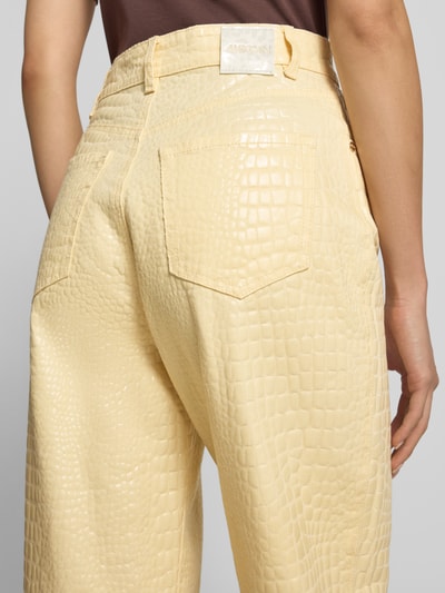 Frauenmodel trägt Relaxed Fit Hose im Allover-Look von Marc Cain in Beige mit Krokodilstruktur, Baumwoll-Elasthan-Mix, Nahaufnahme Rückansicht.