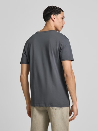 Mannenmodel draagt T-shirt met Label-Detail model 'BASIC' van Alpha Industries, puur katoen, recht model, ruglengte maat M 69 cm, ganzkörperansicht rückansicht.