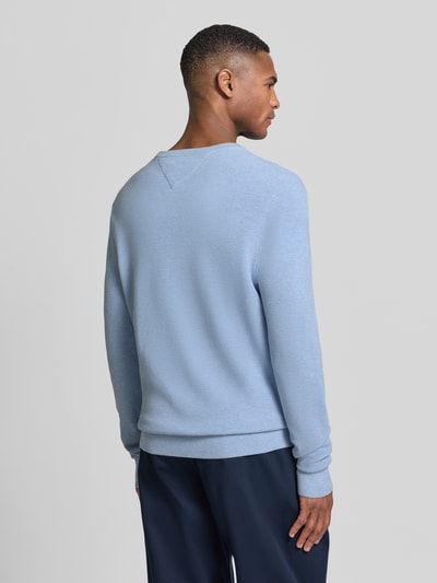 Männermodel trägt Regular Fit Strickpullover aus reiner Baumwolle von Tommy Hilfiger in effen lichtblauw met gebreide look, logodetail, ronde hals, lange mouw, geribde mouwboorden en rompzoom, puur katoen; ganzkörperansicht rückansicht.