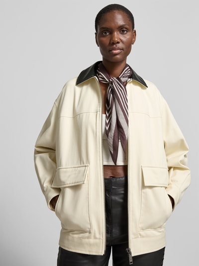 Frauenmodel trägt Relaxed Fit Jacke mit Umlegekragen von Anine Bing aus Reiner Baumwolle, AufgesetzteTaschen, Reißverschluss, cremefarbener Stoff, Rückenlänge 70 cm, Brustweite 59 cm, Ärmellänge 55 cm, Ganzkörperansicht von vorne.