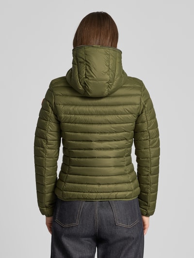 Frauenmodel trägt Steppjacke mit Kapuze Modell 'DAISY' von SAVE THE DUCK in Olivgrün, taillierte Passform, Ganzkörperansicht Rückansicht.