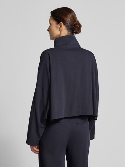 Vrouwenmodel draagt Relaxed Fit blazer met viscose, model 'Elstow' van Drykorn, elastische materiaalmix, opstaande kraag, opgestikte zakken, ritssluiting, donkerblauw, rechte vormen, structuur zacht, ruglengte maat 36: 50 cm, borstwijdte: 75 cm, mouwlengte: 41 cm, model uit damescollectie, model 'Elstow', geheellichaamsaanzicht achteraan.