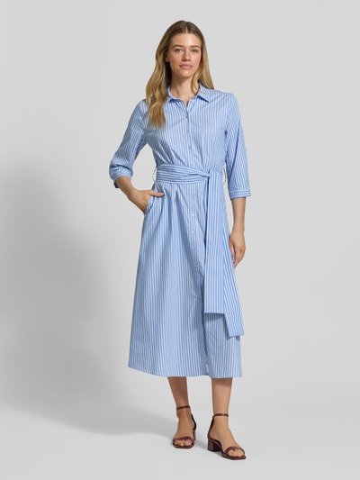 Modelka nosi Hemdblusenkleid aus Baumwoll-Viskose-Mix mit Bindegürtel von Milano Italy, niebiesko-białe paski, A-linia, długość midi, kołnierzyk koszulowy, pasek, długość tyłu w rozmiarze 36: 123 cm, szerokość w rozmiarze 36: 44 cm, długość rękawa w rozmiarze 36: 28 cm, pełen widok z przodu