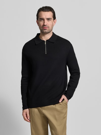 Männermodel trägt Relaxed Fit Pullover aus Viskose-Mix Modell 'TELLER' von SELECTED HOMME in Schwarz, Feinstrick, unifarben, Ganzkörperansicht von vorne.