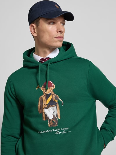 Männermodel trägt Regular Fit Hoodie aus Baumwoll-Mix von Polo Ralph Lauren, Optik: Unifarben, Motiv-Print, Sweat, Ganzkörperansicht von vorne.