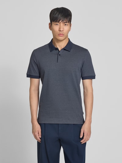 Męski model nosi koszulkę polo Regular Fit Poloshirt aus reiner Baumwolle Modell 'H-PARLAY 102' von BOSS, dwukolorowy efekt, krój regular fit, kołnierzyk polo, krótkie zapięcie na guziki, krótki rękaw, wykończenie z rozcięciami po bokach, z bawełny, odcień ciemnoniebieski, widok całej sylwetki z przodu.