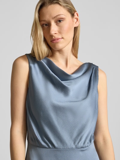 Modelka nosi sukienkę koktajlową 'Cocktailkleid mit Wasserfall-Ausschnitt' od Swing w kolorze jasnoniebieskim, taliowany krój, sukienka midi, lejący dekolt, zamek błyskawiczny z tyłu, długość tyłu w rozmiarze 36: 128 cm, szerokość w rozmiarze 36: 47 cm, faktura lekko połyskująca, gładka, z przodu zbliżenie na górną część ciała, zbliżenie na tors.