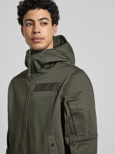 Mannelijk model draagt Regular Fit Regenjacke met rits model 'Batt' van G-Star Raw in olijfgroen katoenmix, capuchon, detailopname bovenlichaam.