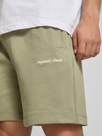 Männermodel trägt Shorts mit Label-Stitching Modell 'KARL' von Jack & Jones aus Baumwoll-Mix in Relaxed-Fit mit seitlichen Eingrifftaschen, Nahaufnahme Oberschenkel.