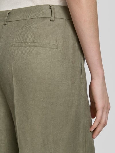 Frauenmodel trägt Leinenhose mit Bügelfalten und Gesäßtasche von Christian Berg Woman Selection, grüne Textur, Detailaufnahme Rückansicht