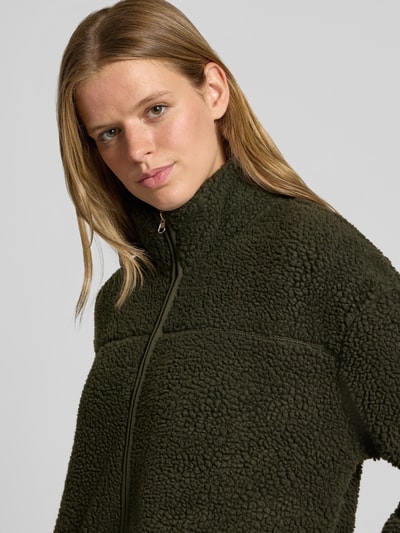 Modelka kobieca nosi Relaxed Fit Teddyjacke mit Stehkragen model 'SAIDA' od PIECES w kolorze ciemnozielonym, tekstura pluszowa, zbliżenie górnej części ciała, kurtka damska teddy/webpelzjacke.
