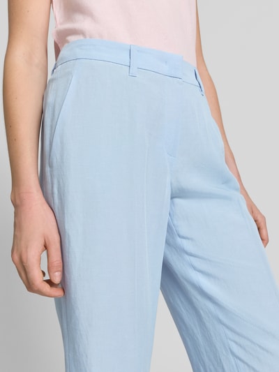 Frauenmodel trägt hellblaue Stoffhose mit Bügelfalten Modell 'OLESSA' von Raffaello Rossi, Viskose-Mix mit Leinen-Anteil, Haken-Reißverschluss, französische Eingrifftaschen, 7/8-Länge, Nahaufnahme Oberkörper