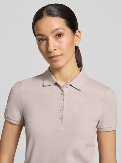 Vrouwenmodel draagt Slim Fit Poloshirt met knoopsluiting van Christian Berg Woman, mix van katoen en elastaan, zijsplitten, ruglengte bij maat S 62 cm, nahaufnahme bovenlichaam.
