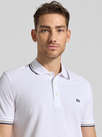 Männermodel trägt Regular Fit Poloshirt mit Kontraststreifen von Christian Berg Men aus Reine Baumwolle, weiße Farbe, Nahaufnahme Oberkörper.