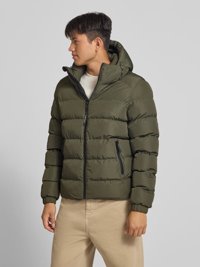 Männermodel trägt Steppjacke mit Label-Stitching und Kapuze von Superdry in Khaki, sichtbarer Reißverschluss, elastische Ärmel, seitliche Taschen, Ganzkörperansicht von vorne. Herren Steppjacke, gerader Schnitt, Kapuze mit Kordelzug, Rückenlänge 67 cm, Schulterbreite 48 cm, Brustweite 58 cm, Ärmellänge 72 cm.