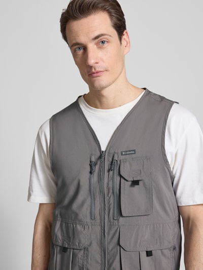 Männermodel trägt Weste mit V-Ausschnitt und Pattentaschen Modell 'SILVER RIDGE' von Columbia in Grau, Nahaufnahme Oberkörper, Regular Fit, Reißverschluss, Rückenlänge 65 cm, Schulterbreite 37 cm, Brustweite 54 cm.