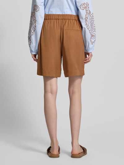 Frauenmodel trägt Straight Fit Shorts und Leinen-Anteil von Marc O'Polo in Unifarbe Braun mit elastischem Bund und Eingrifftaschen, Ganzkörperansicht Rückansicht.