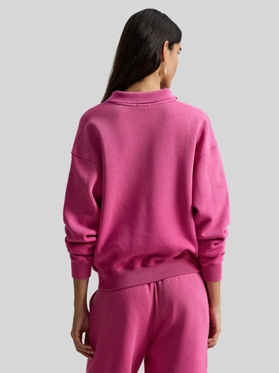 Frauenmodel trägt Regular Fit Sweatshirt aus Baumwoll-Mix von Polo Ralph Lauren in Pink, unifarben, Langarm, gerippte Abschlüsse, Ganzkörperansicht Rückansicht.