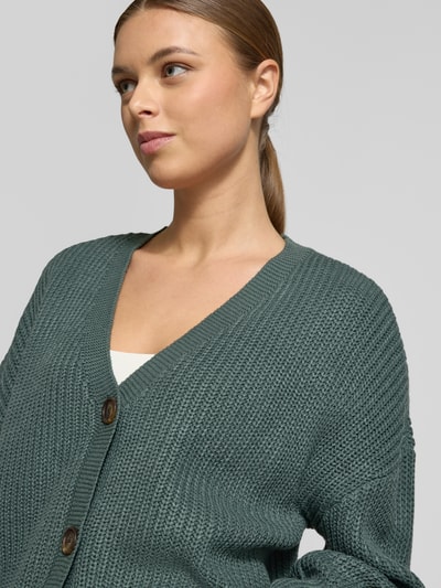 Kobiece modelka nosi Relaxed Fit Strickjacke mit V-Ausschnitt Modell 'LEA' od Vero Moda, melanżowa dzianina, długie rękawy, detaliczne ujęcie górnej części ciała